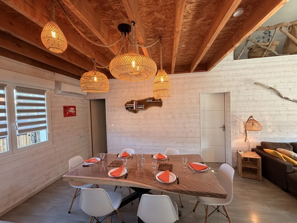 Salle à manger dressée sous les luminaires en rotin